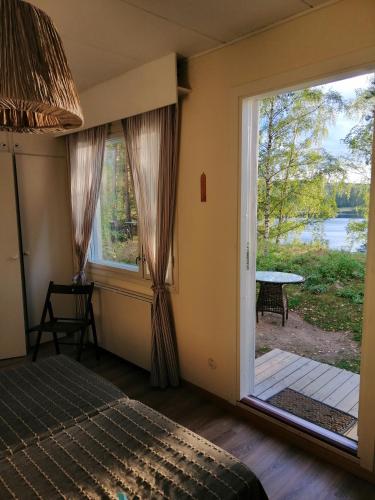 a bedroom with a bed and a large sliding glass door at Vuori Camp by Saimaa in Vuoriniemi