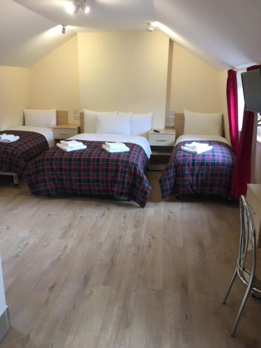 two beds in a room with wooden floors at 15 New Row in London