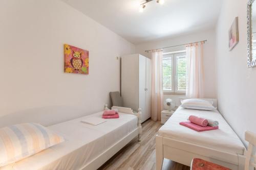 a bedroom with two beds with pink pillows on them at Holiday Home Tamjan in Supetar