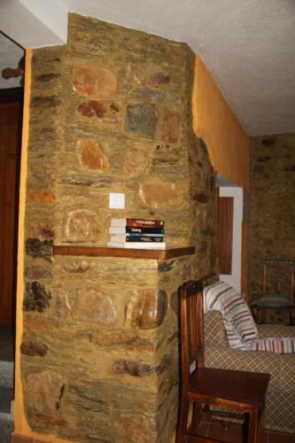 a stone wall with a book shelf in a room at Casa Do Quelho in Janeiro de Cima