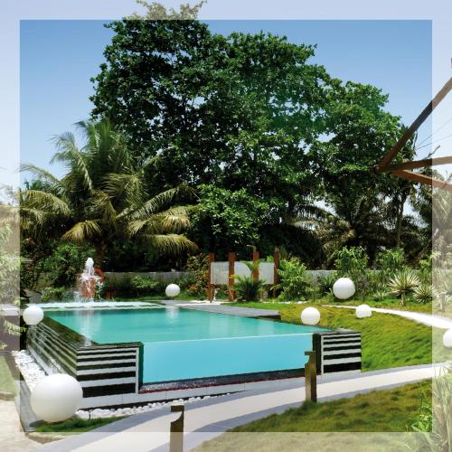 a swimming pool with two chairs and a fountain at Red Mango Hotel and Apartments in Takoradi