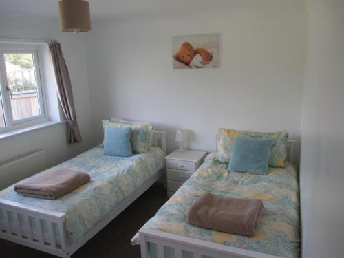 a bedroom with two beds and a window at The Bungalow Lymington 1 mile from New Forest in Lymington
