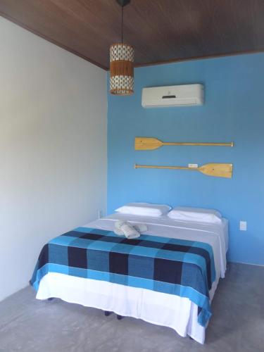 1 dormitorio azul con 1 cama con pared azul en Pousada Angels en Barra Grande