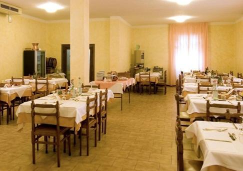 a room filled with tables and chairs with white tablecloths at Hotel Belvedere in Castrocaro Terme