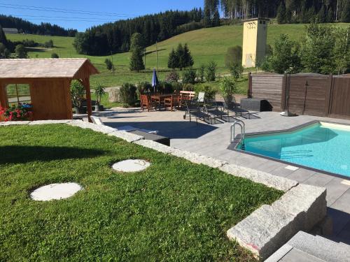 un patio trasero con piscina y mesa de picnic en Pension Altvogtshof, en Eisenbach