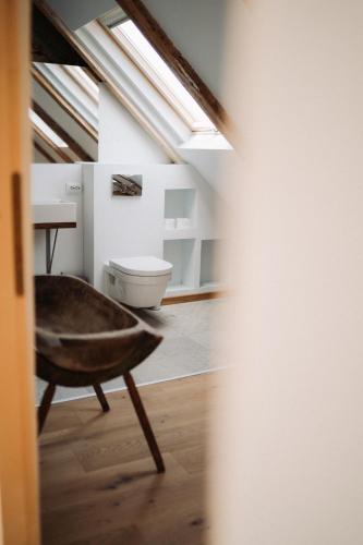 a bathroom with a toilet and a chair in it at 331 in Porumbacu de Sus