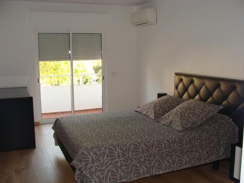 ファロにあるCasa do Largoのベッドルーム1室(ベッド1台、大きな窓付)