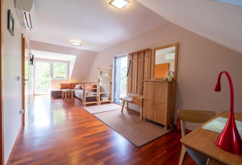 een woonkamer met houten vloeren en een kamer met een spiegel bij Apartments Apple Garden-2 in Bled