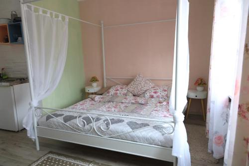 a bedroom with a white canopy bed with pink walls at Apartment Viktoria in Püttlingen