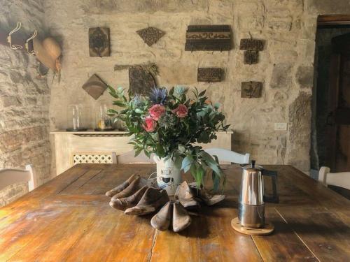 un tavolo con un vaso di fiori e scarpe sopra di Ca' Maranghi Holiday House a Palazzuolo sul Senio