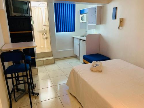 Habitación pequeña con cama y cocina en Hotel H Montreal en Guadalajara