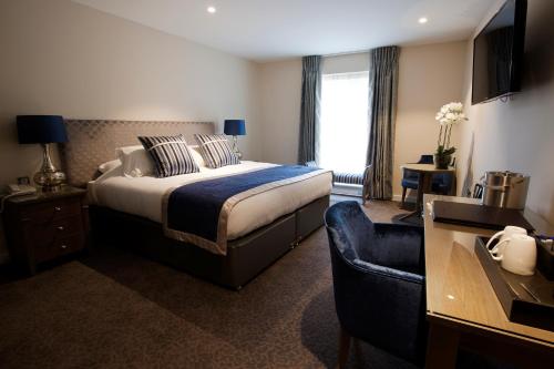 a hotel room with a bed and a couch at Sandford Springs Hotel and Golf Club in Kingsclere