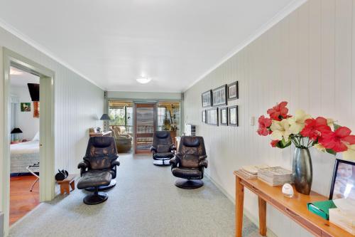 a living room with two chairs and a desk and flowers at Amamoor Homestead and Country Cottages in Amamoor