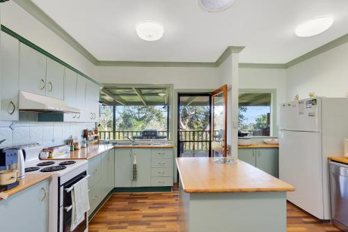 una grande cucina con elettrodomestici bianchi e pavimenti in legno di Amamoor Homestead and Country Cottages ad Amamoor