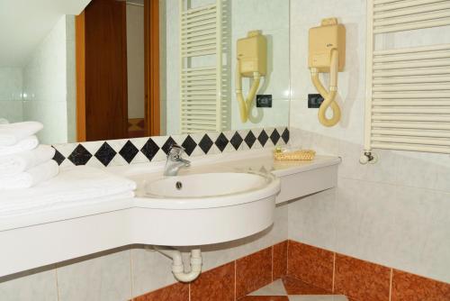 La salle de bains blanche est pourvue d'un lavabo et d'un miroir. dans l'établissement Hotel Amadeus E Teatro, à Turin
