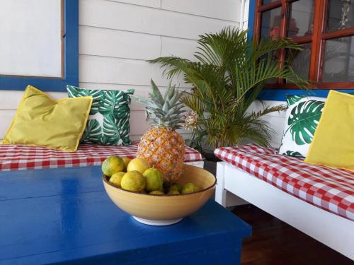 uma taça de fruta numa mesa azul ao lado de um sofá em Hostal del Mar - Main Street em Bocas del Toro