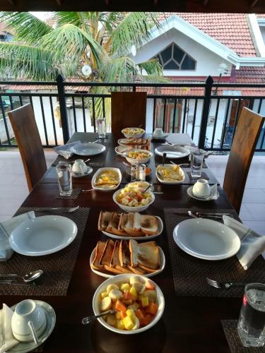 ein langer Tisch mit Tellern voller Essen darauf in der Unterkunft Brisa Marina in Negombo