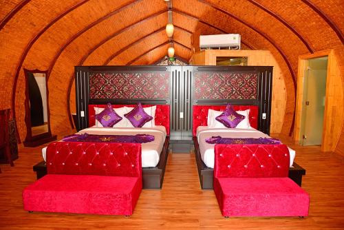 a bedroom with two beds with red cushions at Con Khuong Resort Can Tho in Can Tho