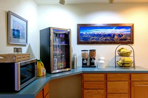 a kitchen counter with a microwave and a refrigerator at The Gunnison Inn at Dos Rios Golf Course in Gunnison