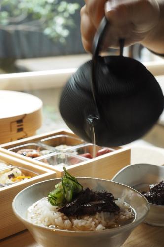 a person holding a spoon over a bowl of rice at Hotel Koo Otsuhyakucho in Otsu