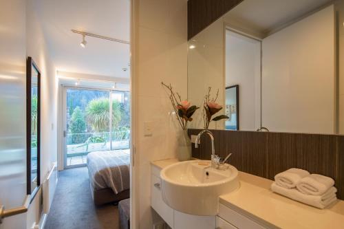 a bathroom with a sink and a mirror at Kent Street Apartments - Element Escapes in Queenstown