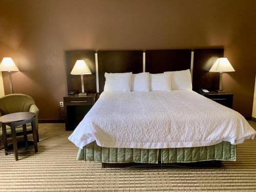 a hotel room with a large bed and a chair at Whitney Inn & Suites in Hamden