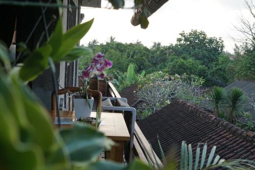 a table with a vase of flowers on a balcony at Raditya House in Ubud