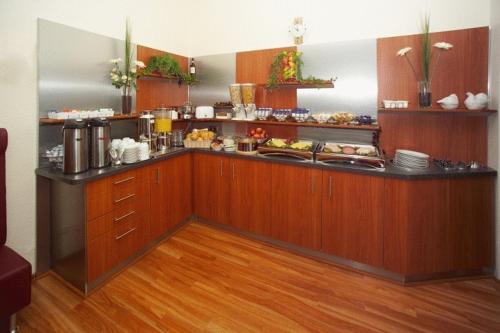 a kitchen with a counter with food on it at Hotel Terminus am Hauptbahnhof & ZOB in Hamburg