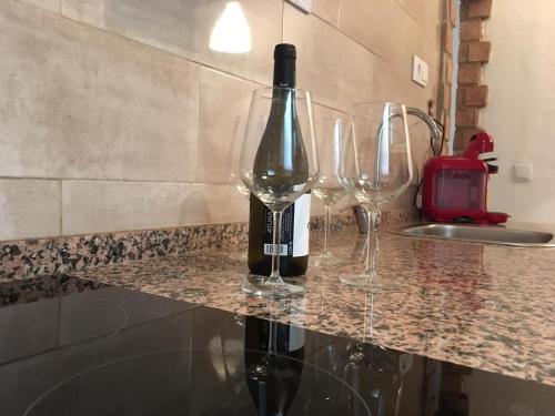 een fles wijn op een aanrecht met twee wijnglazen bij Casa Maria in Rota