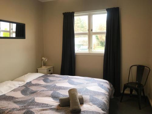a bedroom with a bed and a window at Twizel Holiday Park in Twizel