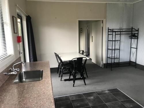 a kitchen with a table, chairs and a refrigerator at Twizel Holiday Park in Twizel