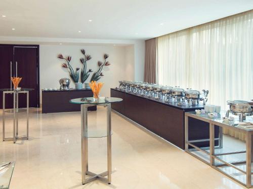 a restaurant with a counter with glasses on it at Mercure Hyderabad KCP Banjara Hills, An Accor Hotel in Hyderabad