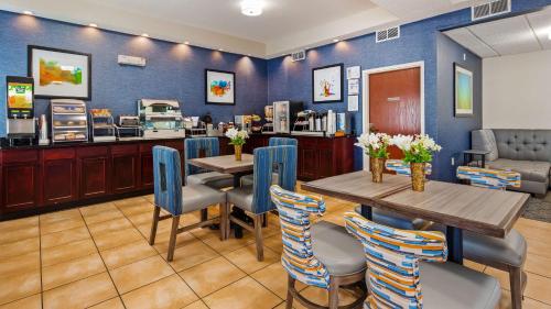 a restaurant with blue walls and tables and chairs at Best Western Hiram Inn and Suites in Hiram