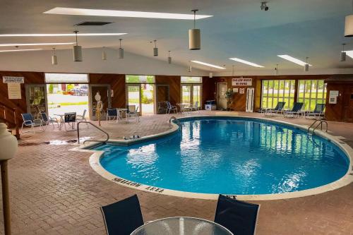 a swimming pool with a pool table and chairs at Quality Inn & Conference Centre Festival in Stratford