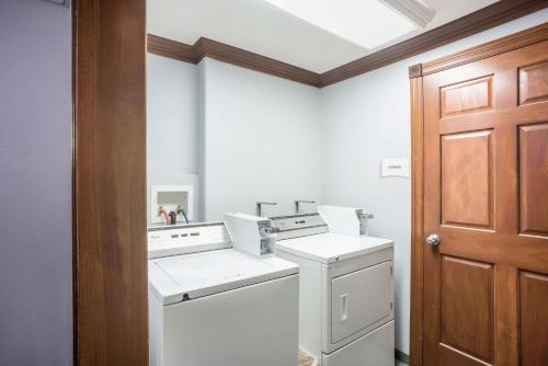 a white laundry room with a washer and dryer at Quality Inn Cedar Rapids South in Cedar Rapids