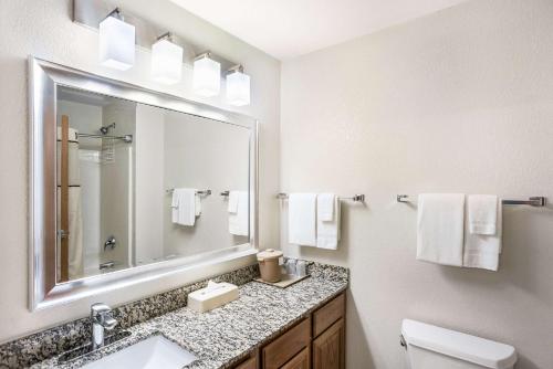 a bathroom with a sink and a mirror at MainStay Suites Cedar Rapids North - Marion in Cedar Rapids
