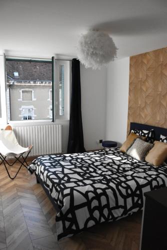 a bedroom with a black and white bed and a window at LE SELECT DE BROU in Bourg-en-Bresse