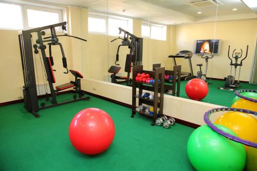 a gym with exercise equipment and balls in a room at Park Hotel Bishkek in Bishkek