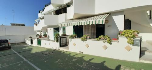 un edificio blanco con plantas a su lado en Il Faro di Anna, en Leuca