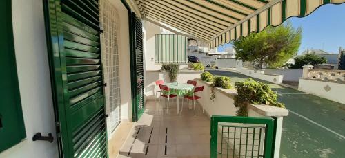 Un balcón con una mesa y sillas en una calle en Il Faro di Anna, en Leuca