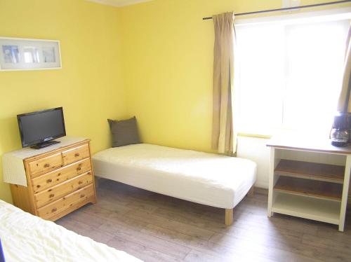 a bedroom with two beds and a tv on a dresser at Bedder at Oslo Airport - serviced apartments in Jessheim