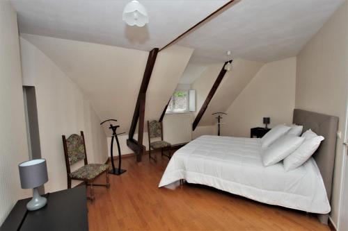 a bedroom with a white bed in a attic at Hôtel Le Régent in Villers-Cotterêts
