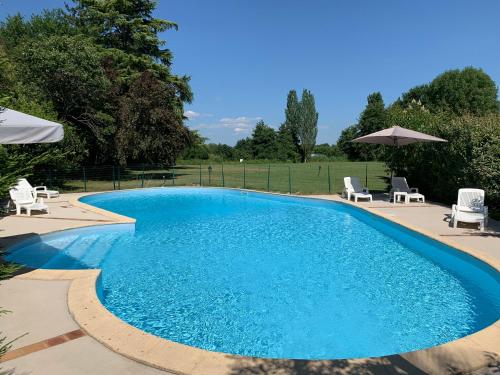 a large swimming pool with chairs and umbrellas at Les Rives du Plantié in Le Temple-sur-Lot