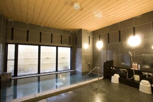 a large bathroom with a sink and a window at Hotel Route-Inn Noshiro in Noshiro