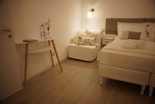 a bedroom with a bed and a chair and a desk at Fermatiqui in Ravenna