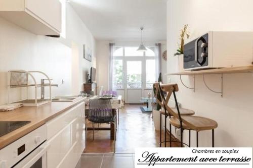 a kitchen with white cabinets and a table and chairs at Ker Edouard in Saint Malo