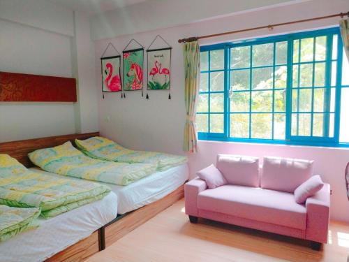 a bedroom with two beds and a couch and a chair at Star Coffee & Homestay in Nanzhuang