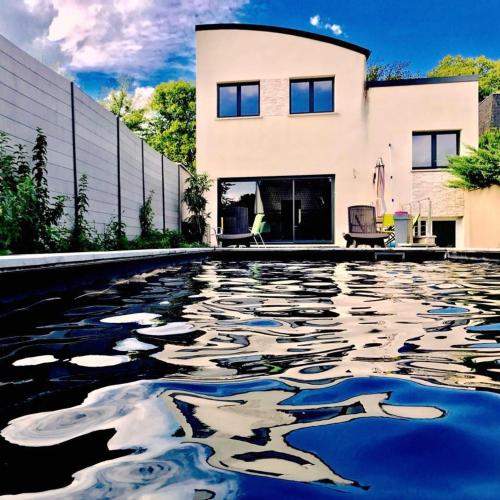 une maison avec une piscine devant une maison dans l'établissement Villa D'Aÿ-Champagne, à Épernay