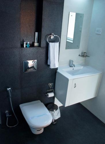 a bathroom with a white toilet and a sink at Gruenberg Tea Plantation Haus in Munnar