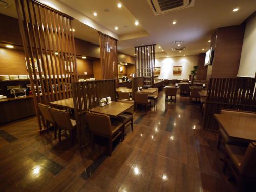 a restaurant with wooden tables and chairs and a dining room at Hotel Route-Inn Seki in Sekimachi